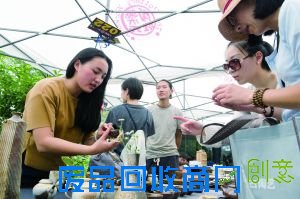 景德镇“九烧”工作室的雷鸣(左一)向顾客介绍作品(6月6日摄)。