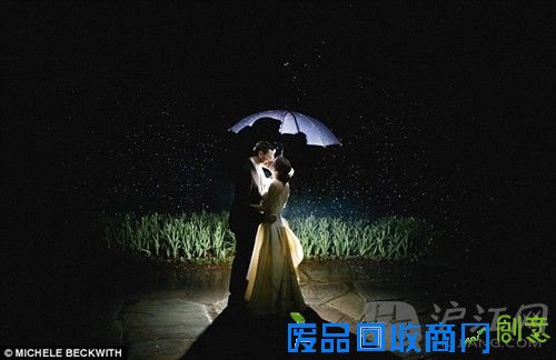 photo5:Lit by a spotlight and protected under their umbrella, the husband and wife in this image share a kiss in the dark outdoors as snowflakes fall around them, giving the illusion of stars. 黑夜里新人伞下拥吻,在聚光灯的照射下,雪花给人的感觉就像星空一般。
