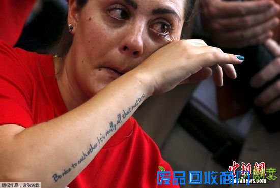 当地时间2015年9月10日，美国华盛顿，一名女子在集会上拭泪，其胳膊上的纹身写着“对彼此友好，这是最重要的事情”，以致敬美国康州桑迪·胡克小学遭枪击遇害的校长多恩·霍克斯普朗。美国国会外举行反对枪支暴力的机会，枪支犯罪遇难者家属出席。