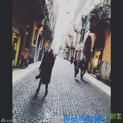 迪丽热巴国外街头拍照 长发披肩头倚城墙美如画