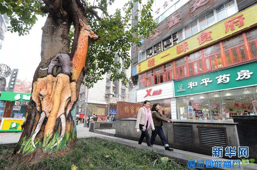 新华社照片，重庆，2016年1月5日 重庆首条创意步行街亮相 1月5日，两名行人从步行街上的一棵彩绘树旁经过。近日，重庆市首条文化创意主题步行街在杨家坪商圈亮相。据了解，杨家坪商圈在进行升级改造中，采用彩绘的方式将步行街的部分行道树、建筑物墙面以及马路隔离墩绘制成“艺术品”。彩绘师在创作时充分结合建筑物和树干的形状特点，绘画不同的动物形象，既美化环境又充满创意。新华社记者 唐奕