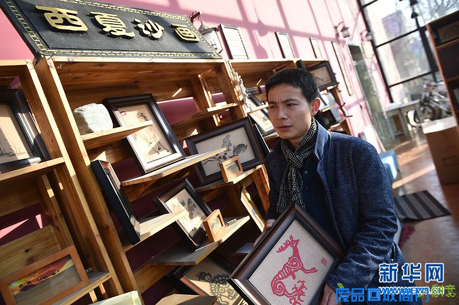 在宁夏银川西夏沙画工作室,刘飞在展示新的流沙工艺沙画(1月4日摄)。