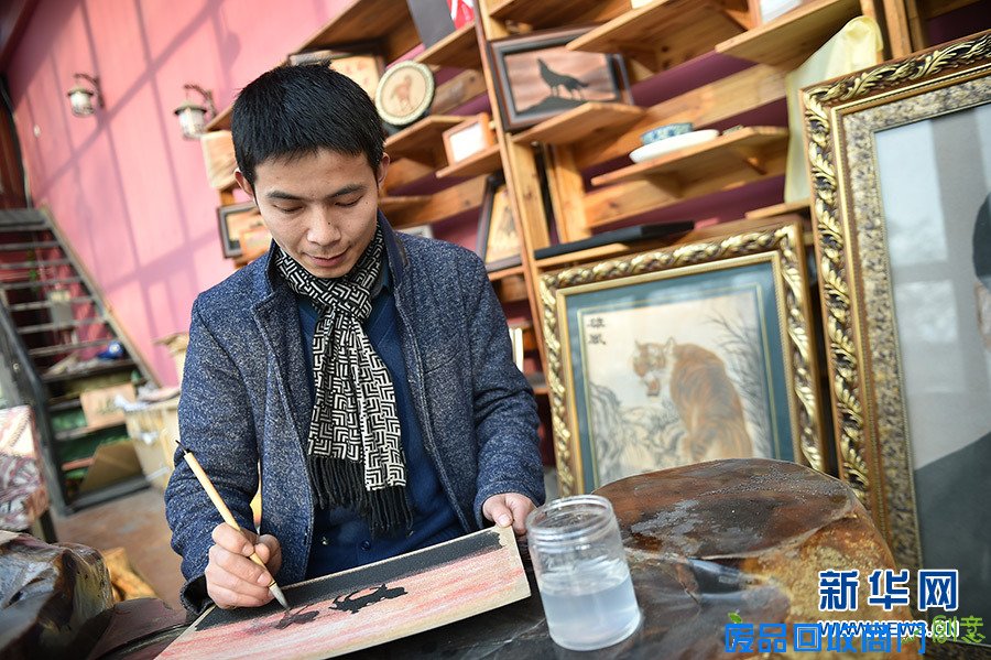 在宁夏银川西夏沙画工作室,刘飞在展示新的流沙工艺沙画(1月4日摄)。