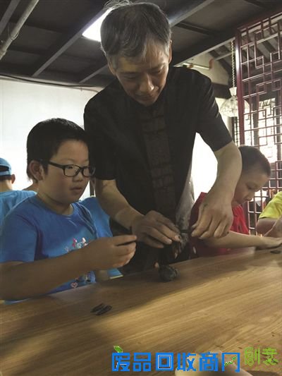 赵建高手把手教孩子捏泥人。