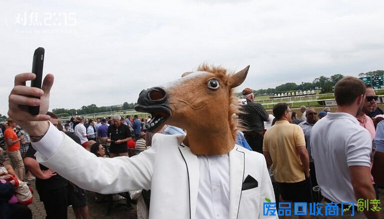 　6月6日，在纽约举行的贝尔蒙特赛马锦标赛期间，一名戴着马头面具的参观者自拍。