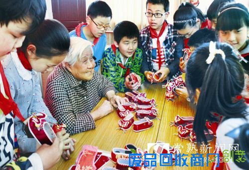 图:91岁的俞增老人在给学生传授“虎头鞋”的制作过程。