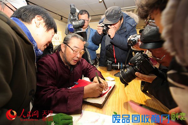 图为天津剪纸艺术家许志齐先生现场创作剪纸作品（1）