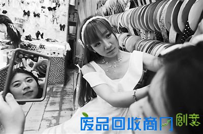 5月25日,在山东济南一家蝴蝶结饰品店,店主姜金香为顾客试戴蝴蝶结饰品。