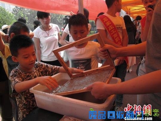 小朋友在造纸匠人的指导下体验手工造纸。　高红超　摄