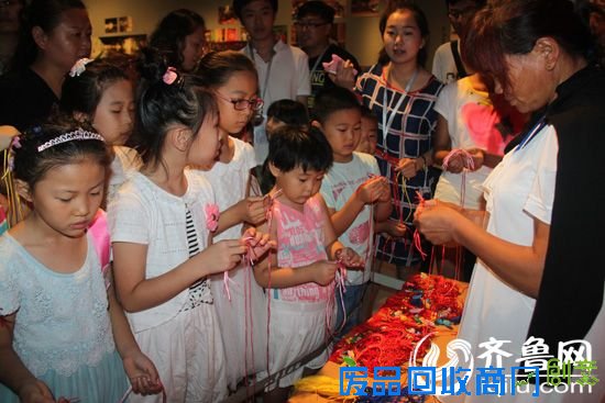 参观展览的孩子们体验编织中国结