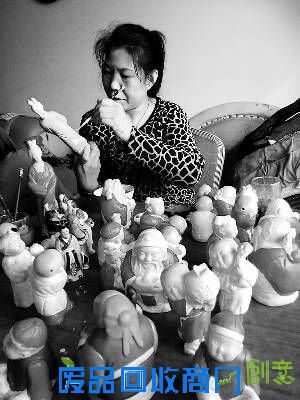 胡秋英正在给泥塑作品上色。