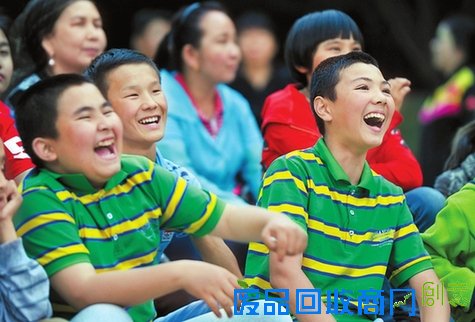 5月31日，首府一家爱心企业走进中国乌鲁木齐SOS儿童村，为儿童村的孩子们播放电影。图为13岁的吐尔逊江（右）和同伴买尔旦被动画电影《超能陆战队》中的剧情逗乐了。