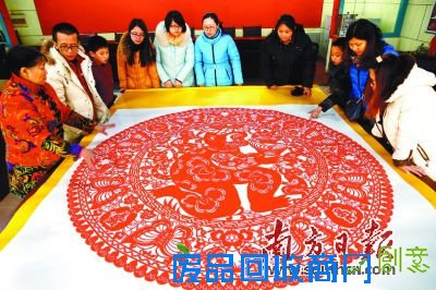 游客欣赏由郭润芝制作的《金猴送宝》大型团花剪纸作品。这幅作品直径两米，历时近三个月完成，寓意“金猴送宝日子越过越好”。