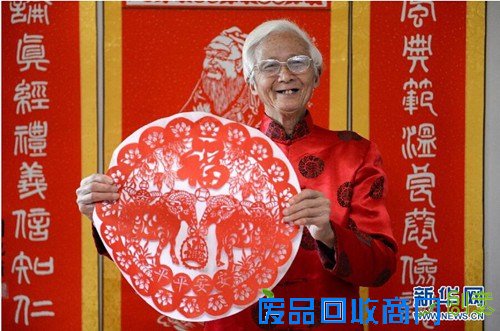 刘纪甫展示为新年创作的剪纸作品《双羊送福》。（万象