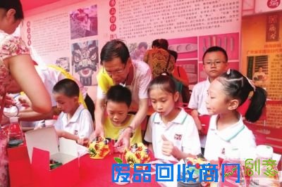 ■国家级非遗传承人黎伟手把手教小朋友扎作狮头。 珠江时报记者/戚伟雄摄