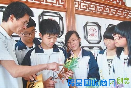 余军进在给学生们上剪纸课