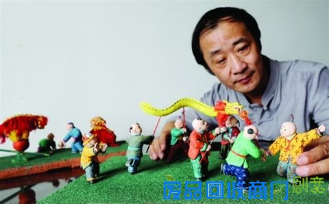 昨天，王开亚展示泥人彩绘系列作品《童趣》中的“舞龙”场景。记者杭兴微摄