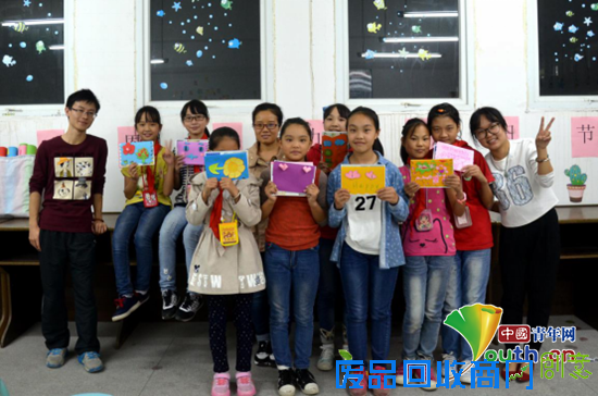 龙胜镇小学留守儿童展示自己制作的贺卡。余龙供图