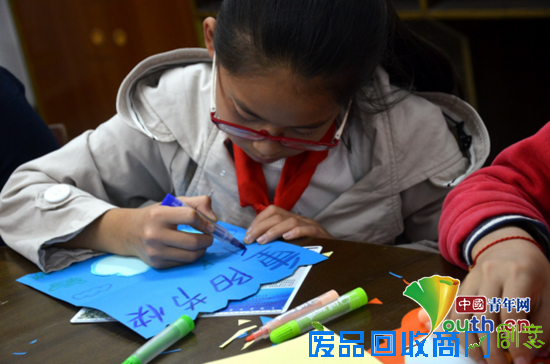 龙胜镇小学留守儿童正在认真制作贺卡。余龙供图