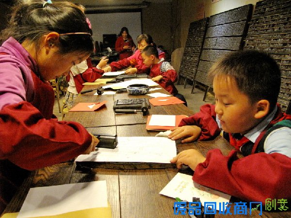 青岛小学生转动印刷老机器制作贺卡 表达对妈妈节日祝福