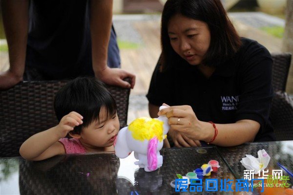 　　9月26日，一对母女在万达西双版纳度假酒店群园区内涂鸦“万小象”。