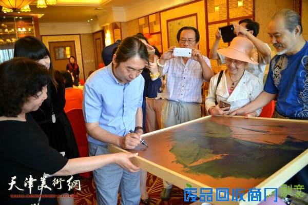 郝跃先在被收藏作品上签名。