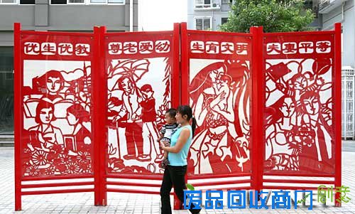 9月7日，浙江省瑞安市沿江社区居民从一块剪纸风格图案的屏风前走过。屏风上的图案为优生优教、尊老爱幼等内容，令人赏心悦目。 新华社发(庄颖昶 摄) 