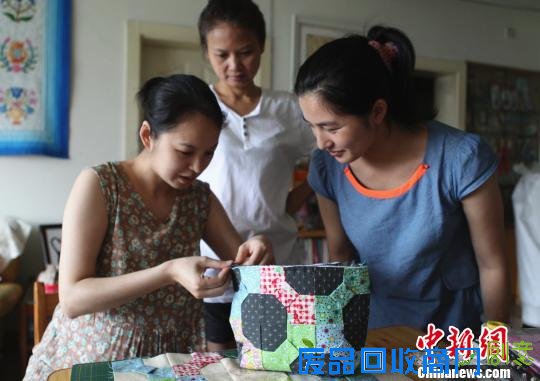 图为李红正在自家客厅指导学员“拼布”技巧。　周毅　摄