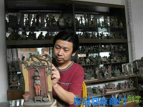 图为刘永强在为泥人作品上色。