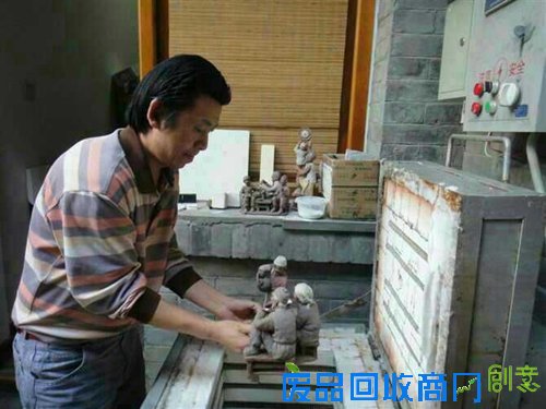 图为刘永强在为作品进行加热定型。