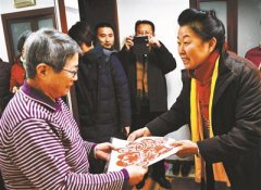 市文联组织艺术家为居民送春联贴窗花(图)
