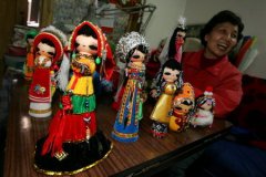 图文：民间艺人在展示手工制作的布娃娃