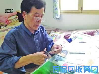 贾师傅正在专心制作报纸剪贴画